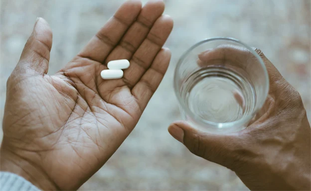 Två tabletter i en handflata.