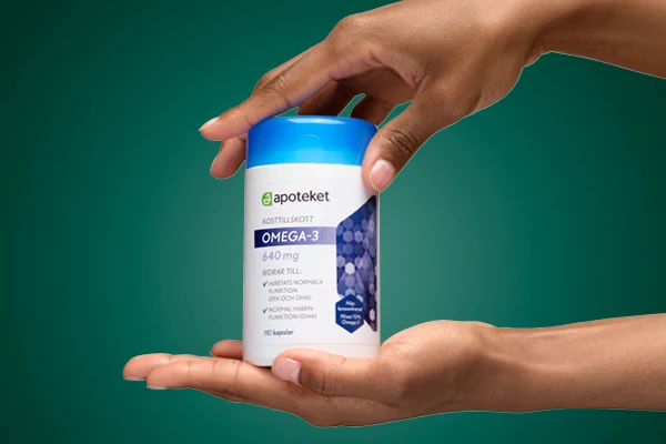 En hand visar upp kosttillskottet "OMEGA 3" från apoteket.