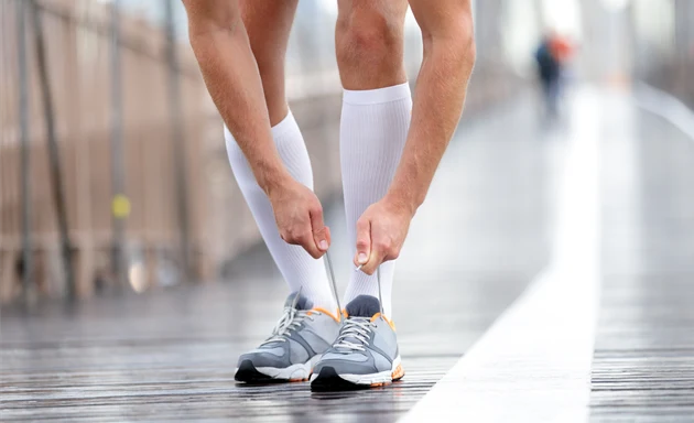 Man som har på sig stödstrumpor på löprundan.