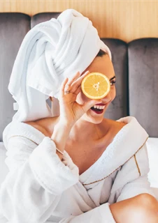 Två vänner med badrockar som diskuterar antioxidanter i hudvård.