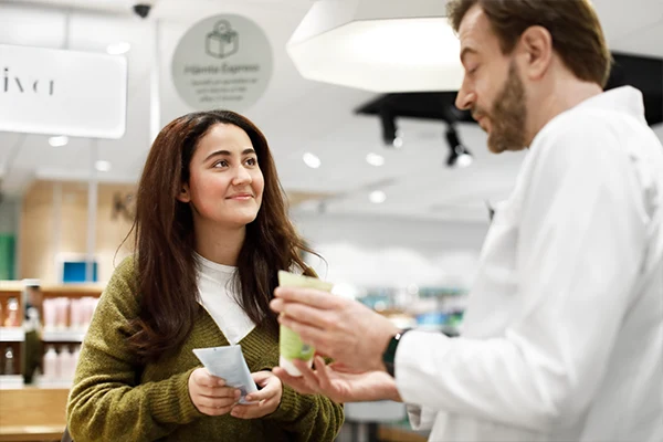 En farmaceut hjälper en kund.