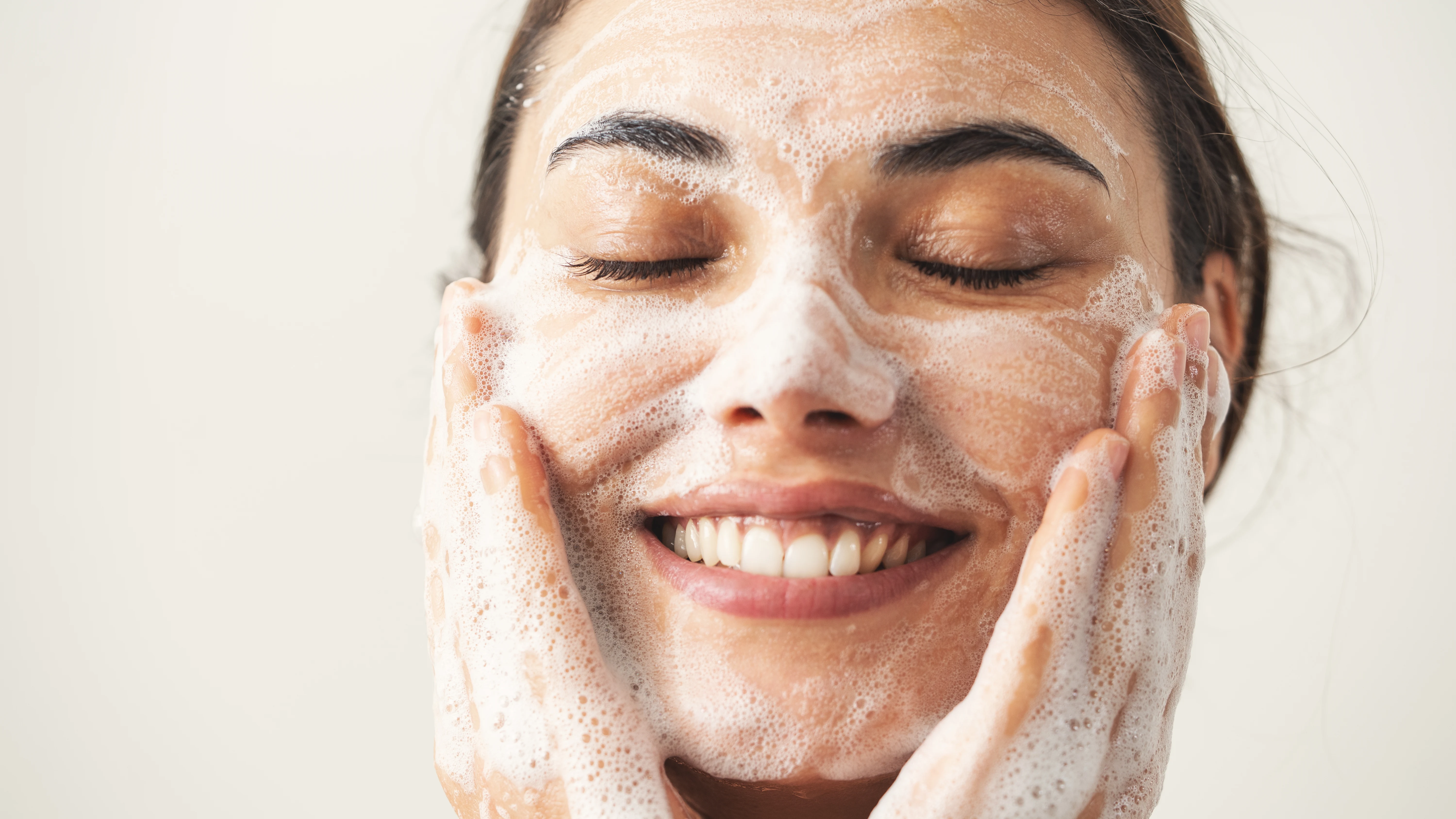 En kvinna rengör sitt ansikte.