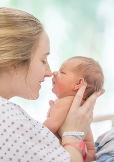 Mamma och nyfödd som bondar på bb.