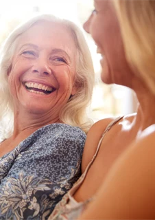 Kvinna som skrattar sig hes med sina väninnor.