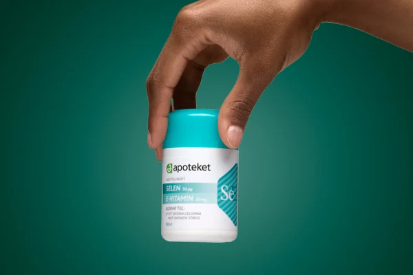 En hand visar upp kosttillskottet "SELEN E-VITAMIN" från apoteket.