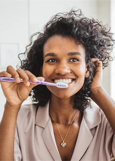 En kvinna borstar sina tänder.