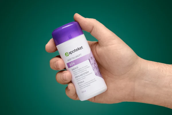 En hand visar upp kosttillskottet "50+" från apoteket.