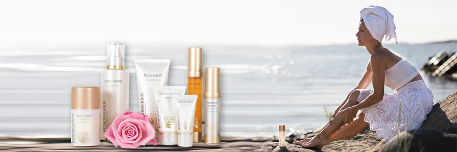 En kvinna sitter på stranden med en handduk på huvudet. 