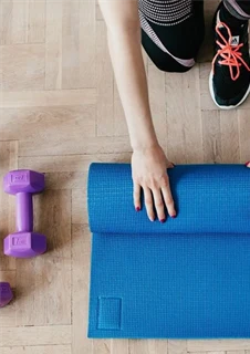 En person som rullar ihop en yoga-matta.