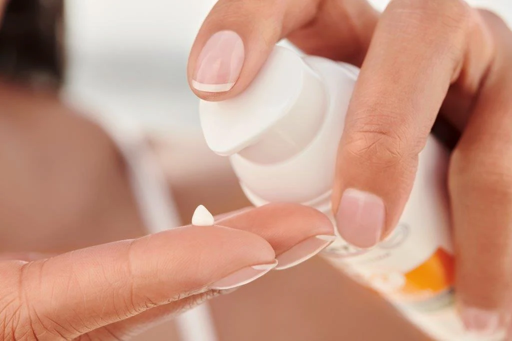 En person som pumpar ut solskydd från en eucerin-förpackning.