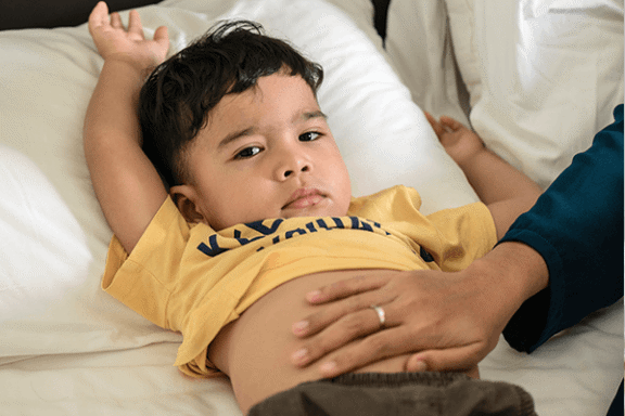 Pojke som fått ont i magen efter att ha druckit mjölk.