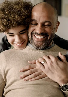 En glad pojke kramar om sin pappa.