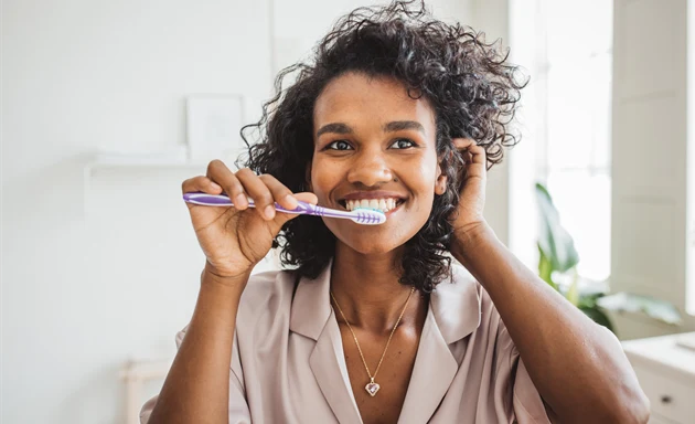 En kvinna borstar sina tänder.