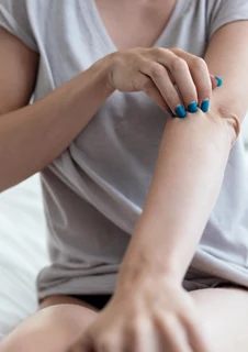 en person som kliar på sin arm.