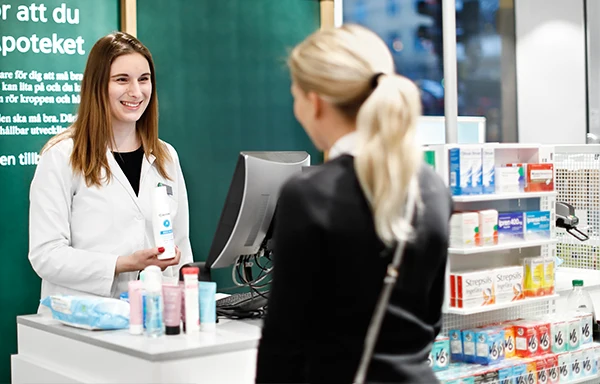 En farmaceut och en kund i ett apotek. 