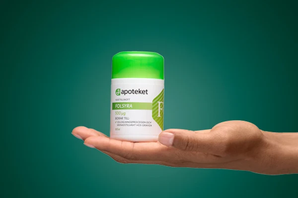 En hand visar upp kosttillskottet "FOLSYRA" från apoteket.