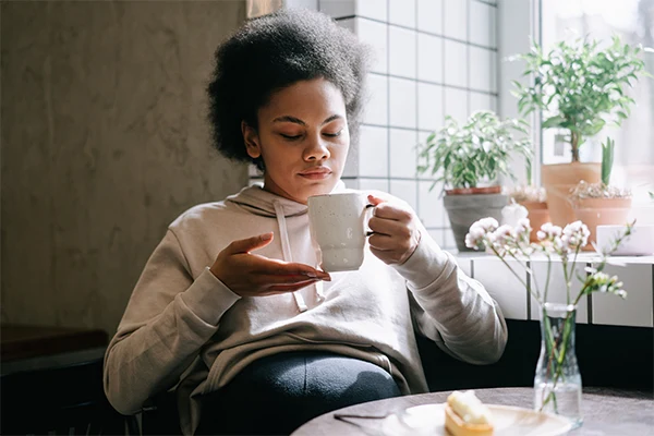 En kvinna som dricker varm dryck. 