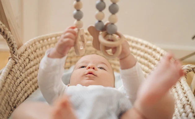 Bebis som leker med en trämobil. Vad är utvecklingssprång?