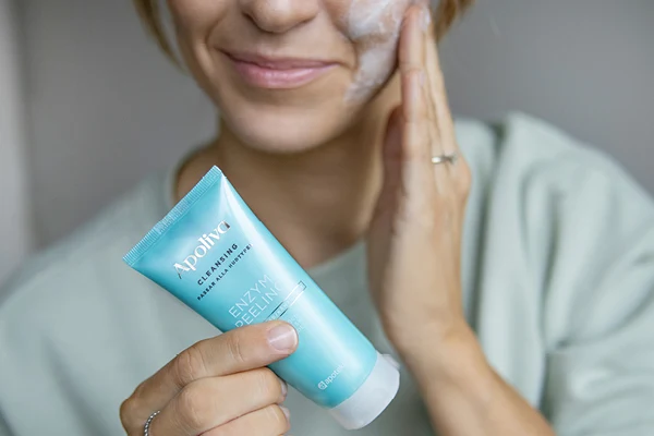 En kvinna applicerar Apolivas Enzympeeling i ansiktet.