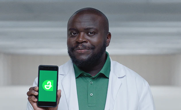En man håller i en mobil och har öppnat Apotekets app.