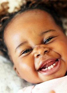 Glad liten flicka som fått sina första tänder.