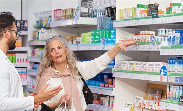 En farmaceut som hjälper en kund på ett apotek.