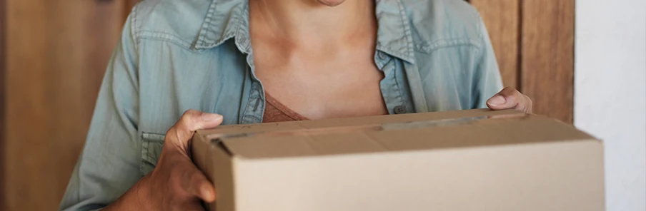 En kvinna som bär på ett paket från apoteket. 