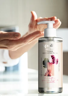 En person tar handsprit från Apoliva. 