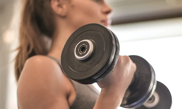 En kvinna som tränar med hjälp av hantlar. 