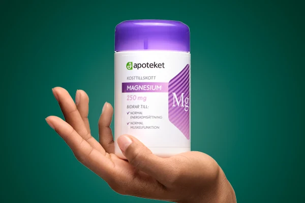 En hand visar upp kosttillskottet "MAGNASIUM" från apoteket.