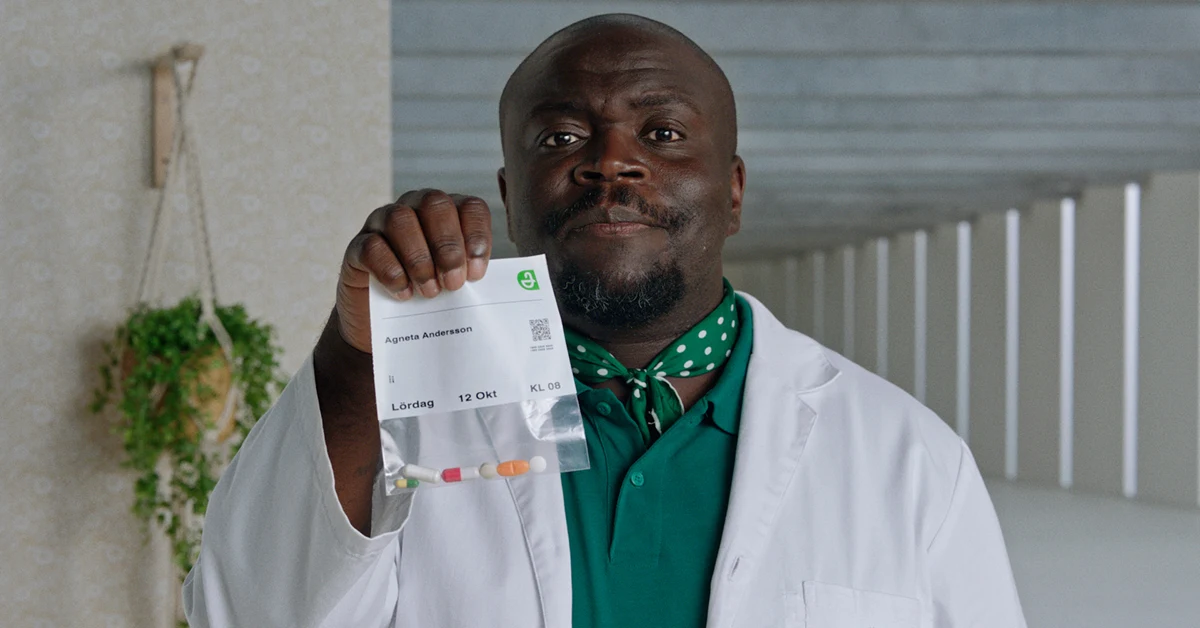 En apotekare håller färdigdoserade läkemedel i dosförpackning i handen.