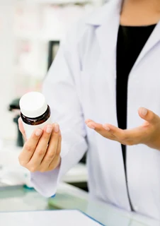 En farmaceut som pratar om en medicin med en kund.