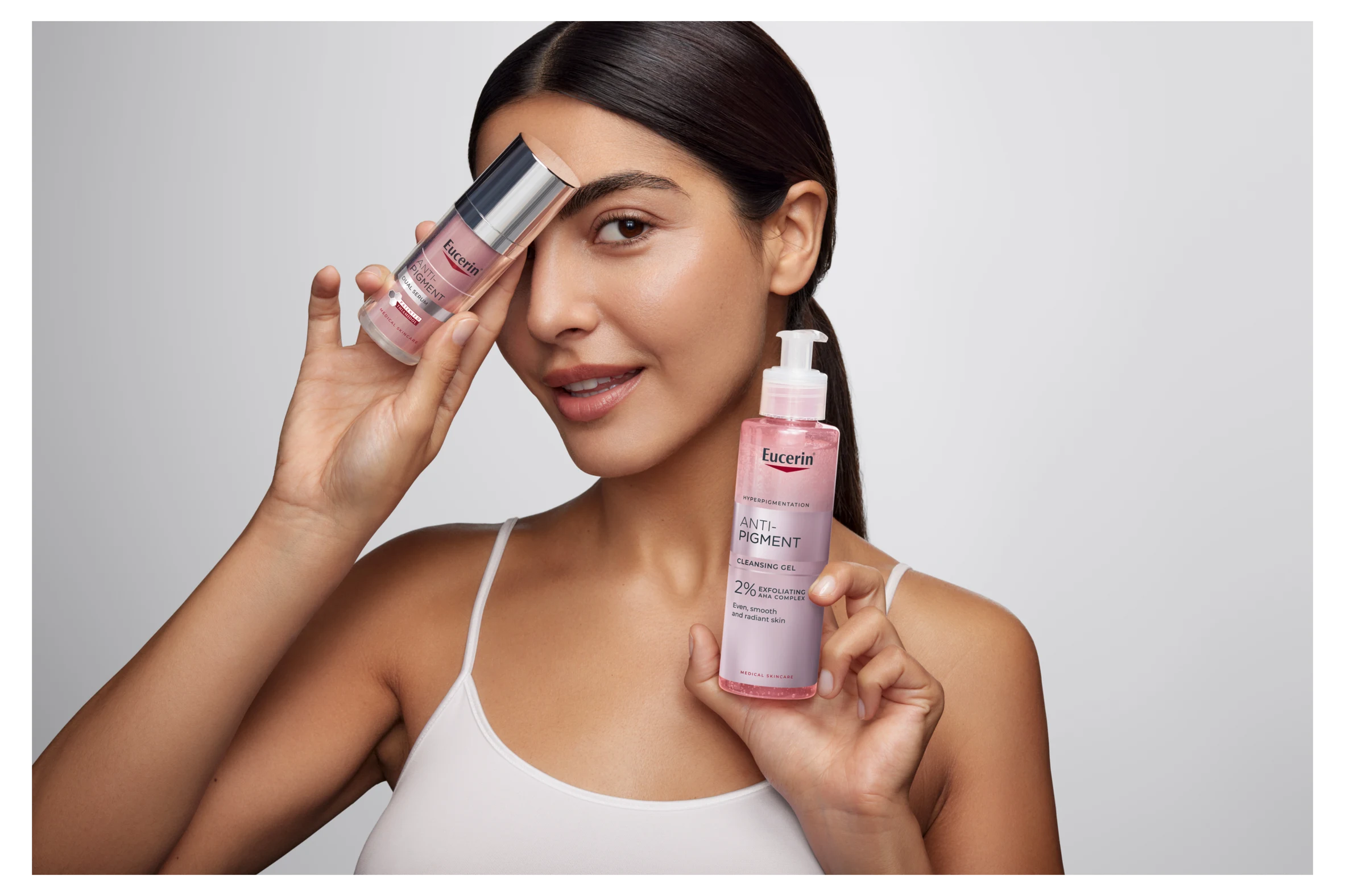Kvinna som håller upp två Eucerin-produkter