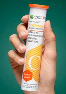 En hand visar upp kosttillskottet "C-VITAMIN" från apoteket.