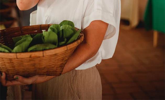 En kvinna som håller upp någon form av grönsak.