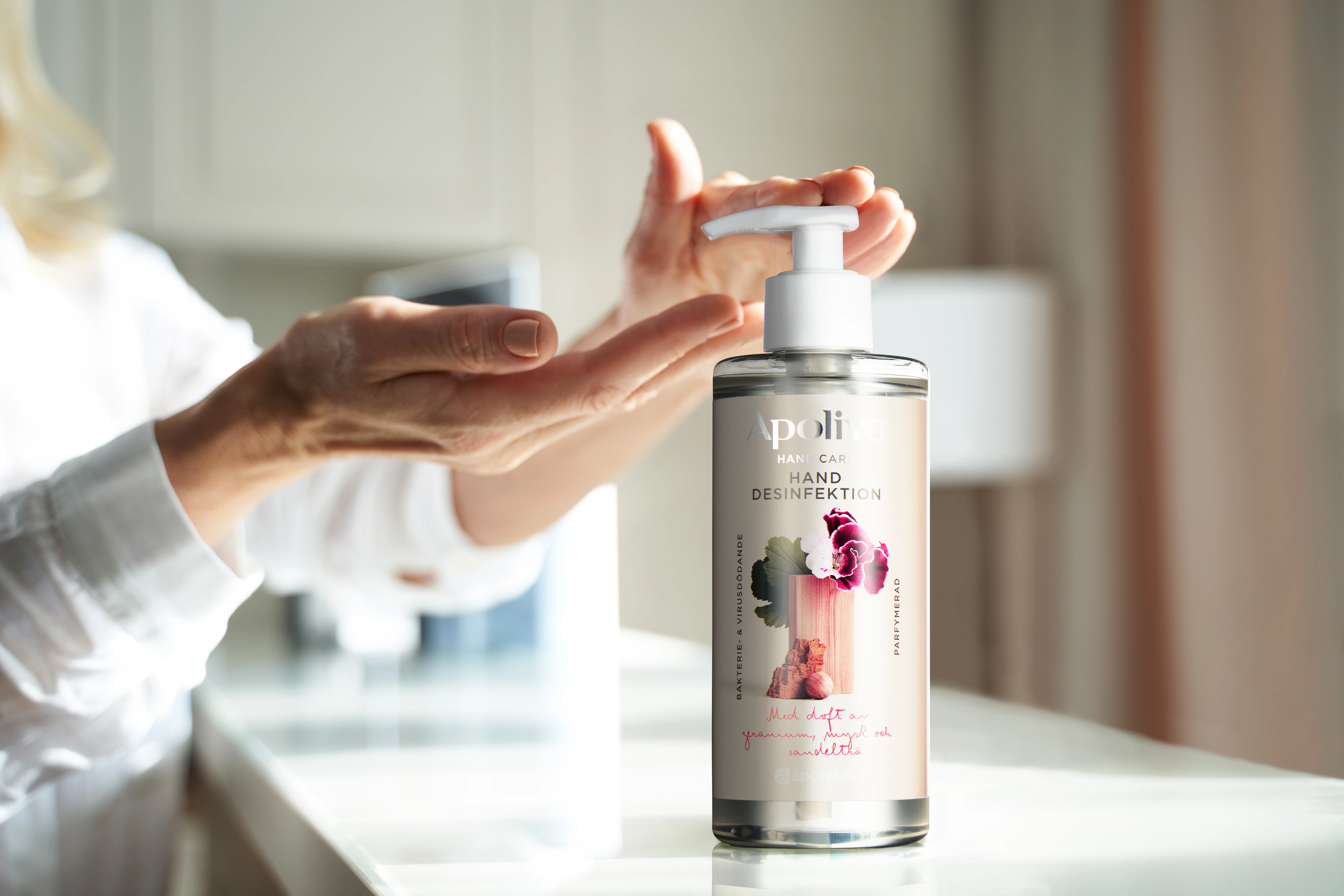 En person tar handsprit från Apoliva. 