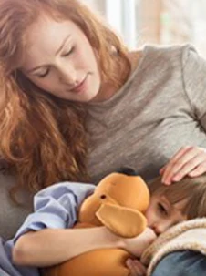 Ett barn som ligger i sin mammas knä. 