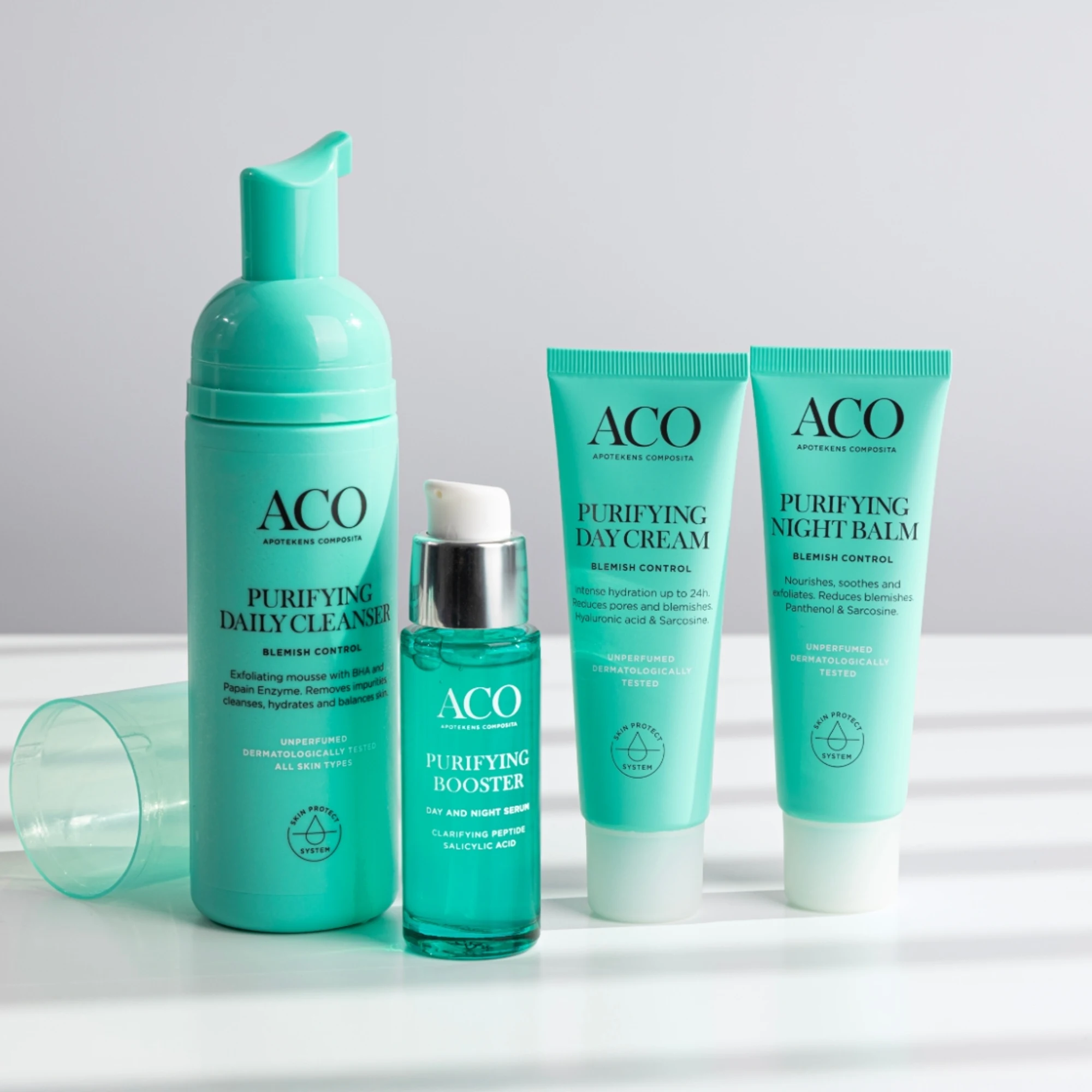 Fyra ACO Purifying produkter på rad på ett bord.