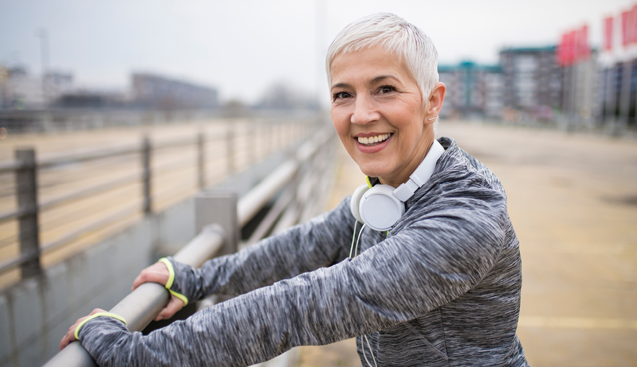En kvinna i träningskläder som ler.