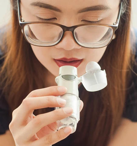 En ung kvinna använder en astmainhalator.