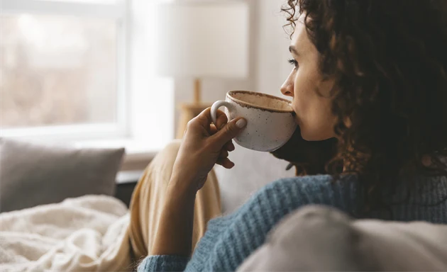 Kvinna med mykoplasma som dricker en varm dryck. 