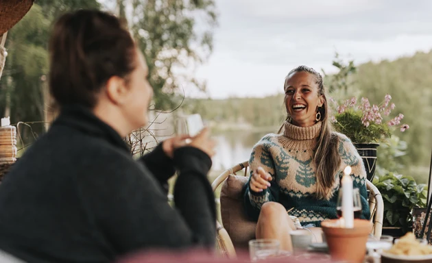 Några kvinnor som sitter på en altan och skrattar.