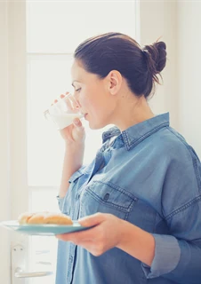 Laktosintolerant kvinna som dricker ett glas mjölk.