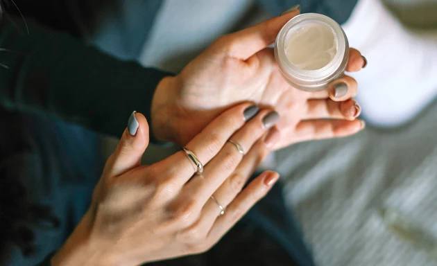 En person som håller i en ansiktskräm.