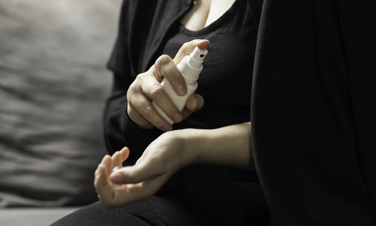 Kvinna i klimakteriet som användar hormonläkemedel i sprayform på handleden för att dämpa sina klimakteriebesvär.