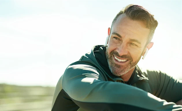 En man klädd i träningskläder som ler.