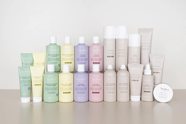Grupp bild på produkter från Apoliva Haircare-serien mot en beige vägg.