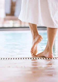 Två personer i badrock som står framför en pool. 