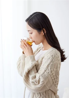 Kvinna som dricker te för att lindra torr hals.