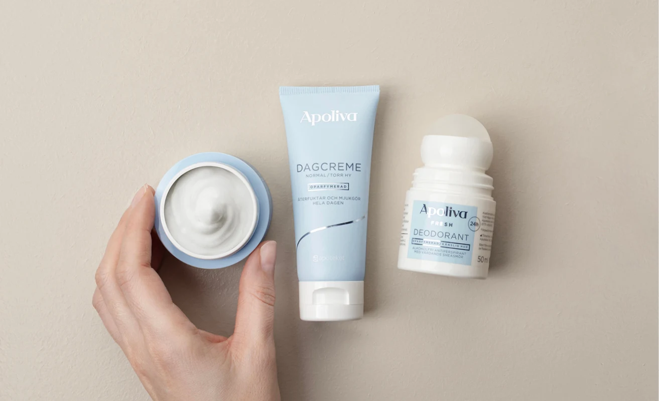 Apoliva dagkräm och roll-on deodorant; hand håller kräm.